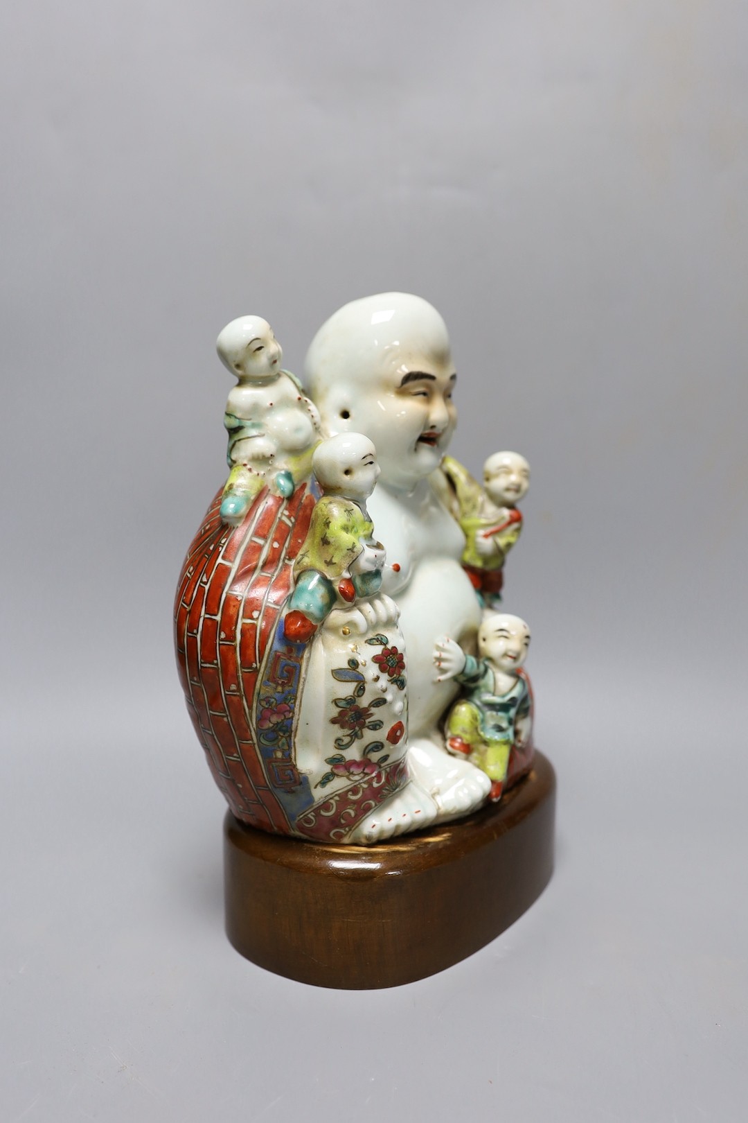 A Chinese enamelled porcelain Budai group, Republic period, on stand 25cm